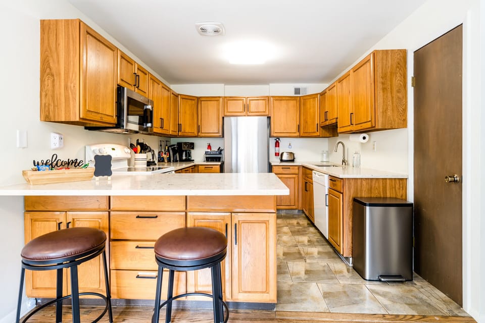 Fully stocked Kitchen on entry of unit with counter top seating