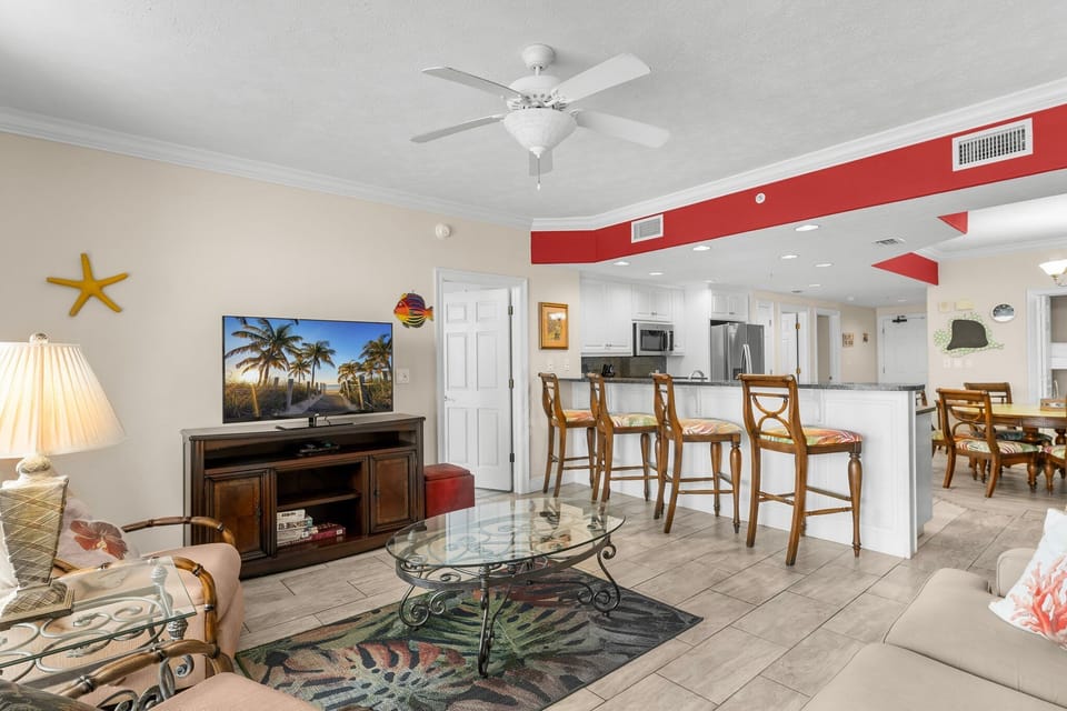 Open living area with a coastal-themed design and a breakfast bar with seating.
