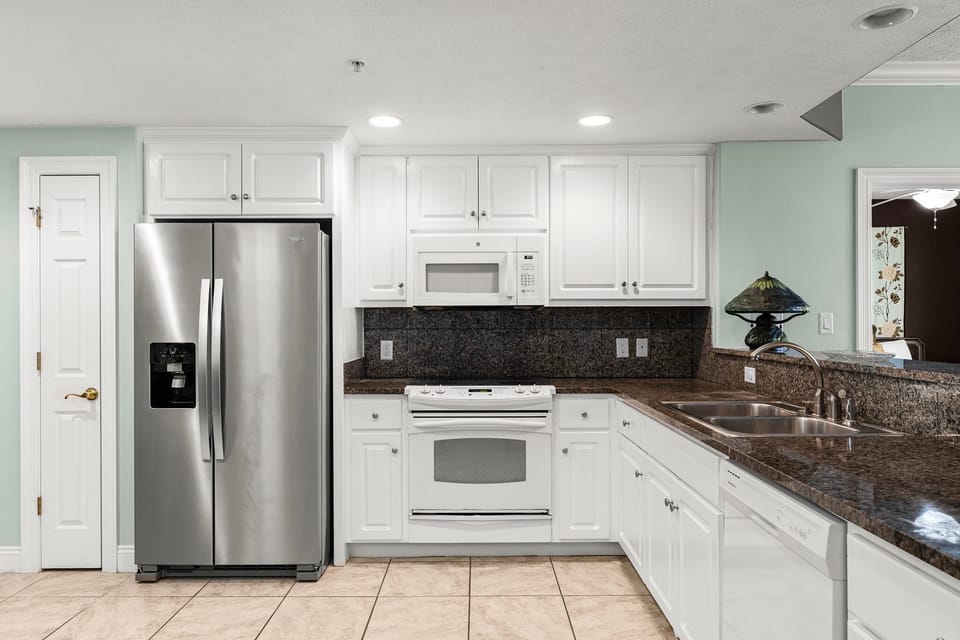 Clean, modern kitchen w/ stainless steel fridge & all the space you need to cook.