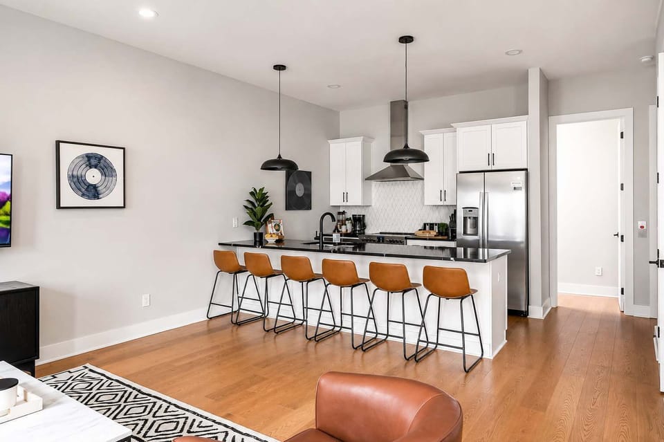 Functional and elegant kitchen with a six-seat island and stainless steel appliances.
