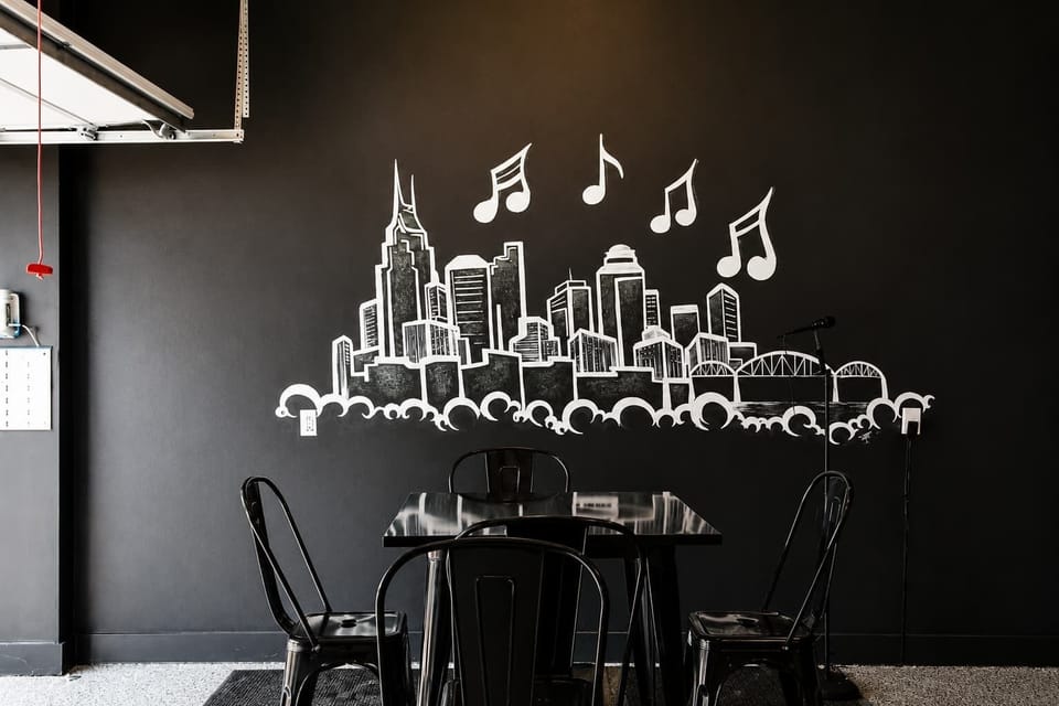 Sophisticated chill area with bold black décor, elevated seating, and a mounted TV.