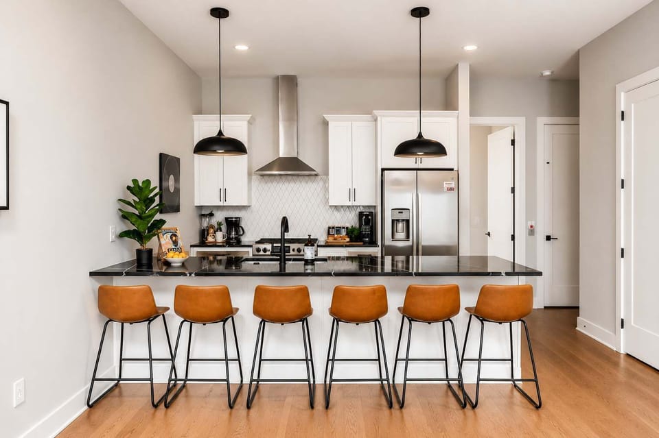 Stylish white kitchen with stainless appliances and a large island for six.