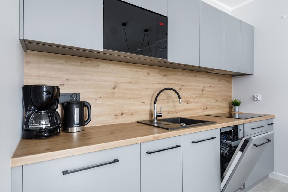 A closer look at the kitchenette area, featuring wooden countertops, modern appliances, and a coffee station.