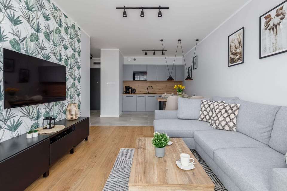 A modern living room featuring a large sofa, a coffee table, and green-themed decorative pillows.