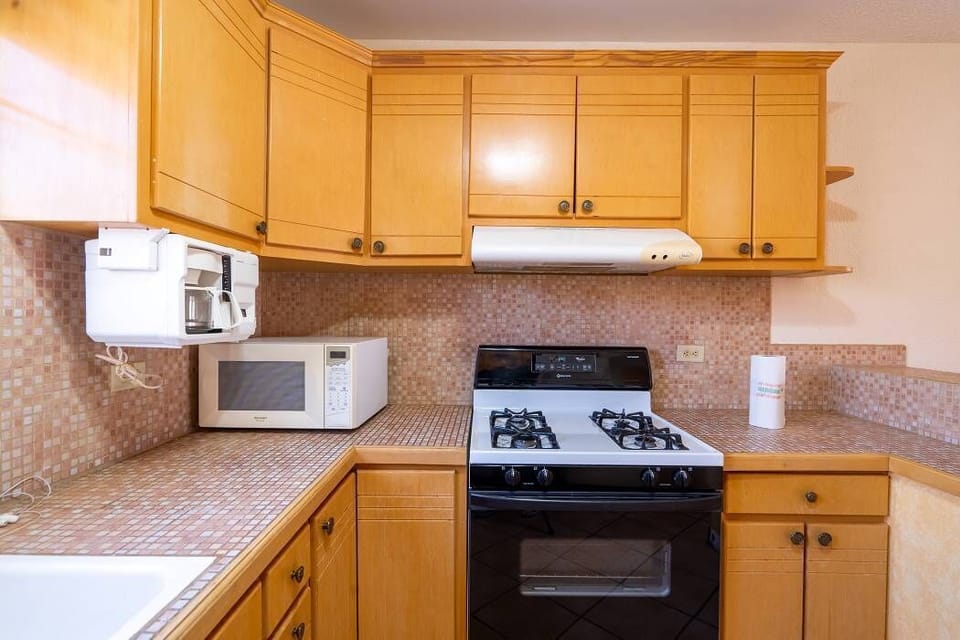 Full kitchen with refrigerator, microwave, and essential cookware at Casa Seascape in Villas de Las Palmas — perfect for home cooking .