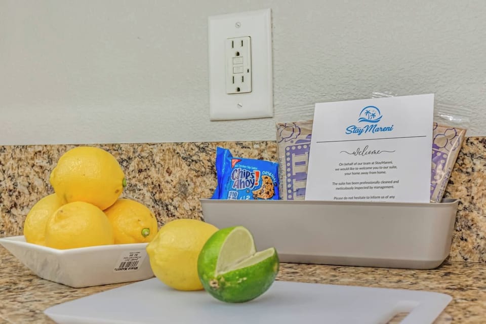 Thoughtful welcome touches on the kitchen counter, with fresh citrus, snacks, and a warm note to help guests feel at home upon arrival.