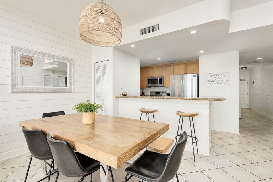 Your open-concept living flows seamlessly from dining to kitchen, where coastal charm meets modern comfort in every detail.
