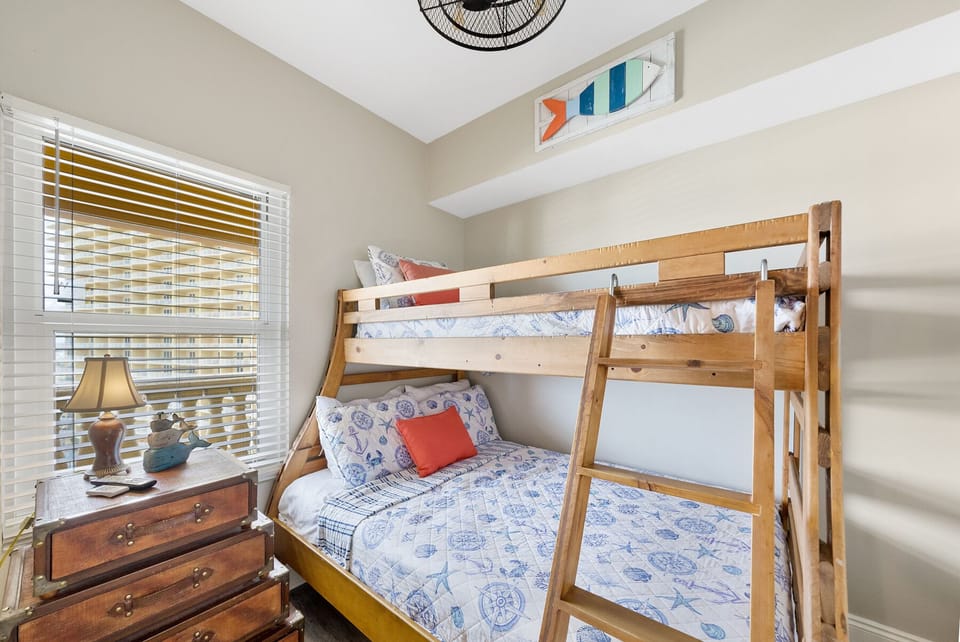 Your kids will love this cozy bunk bed room with nautical-themed bedding and plenty of natural light from the window.
