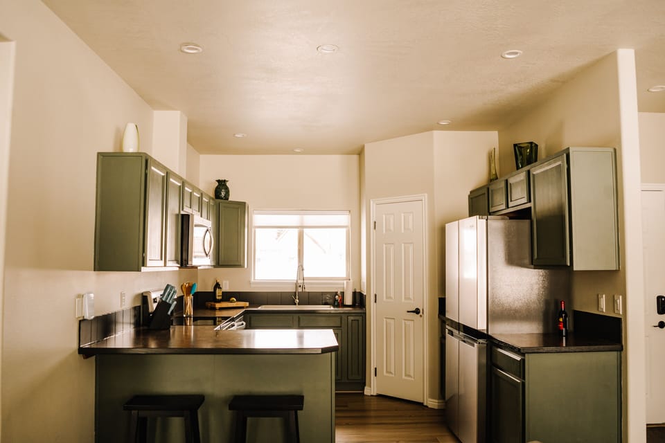 Kitchen with full fridge, freezer, coffee maker, toaster, dishes & utensils.