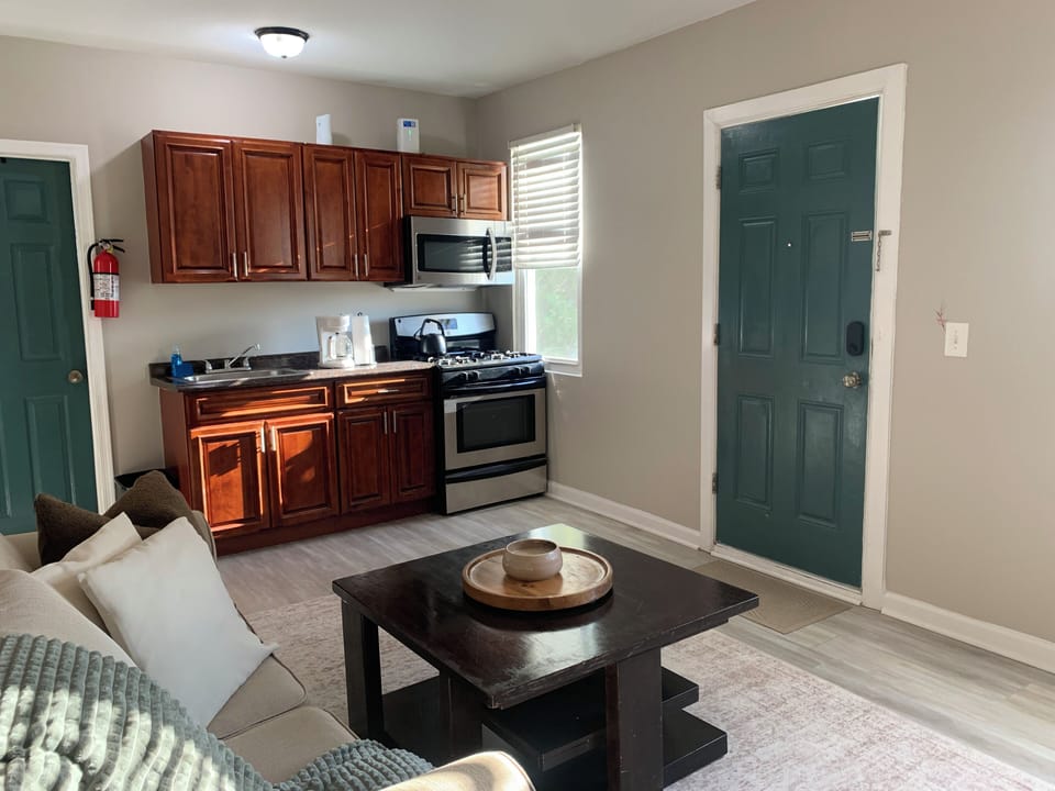 Bright studio-style living space with cozy seating and full kitchenette