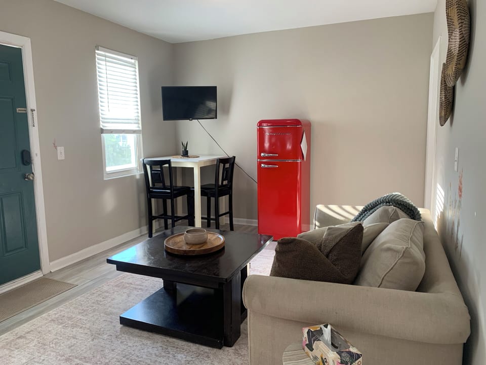 Cozy lounge with TV, dining nook, and stylish retro red mini fridge