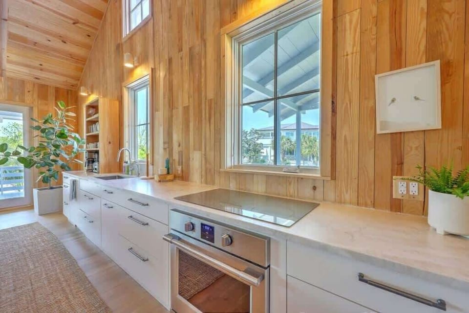Modern kitchen with sleek countertops and large windows for a bright cooking space.