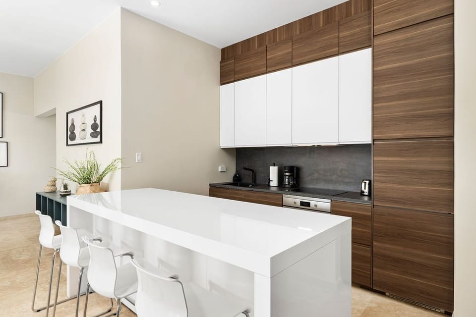 Prepare your morning coffee at the sleek island, surrounded by warm wood tones and modern conveniences that make every meal effortless.