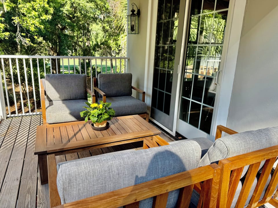 Outdoor lounge area with comfy teak chairs and table.