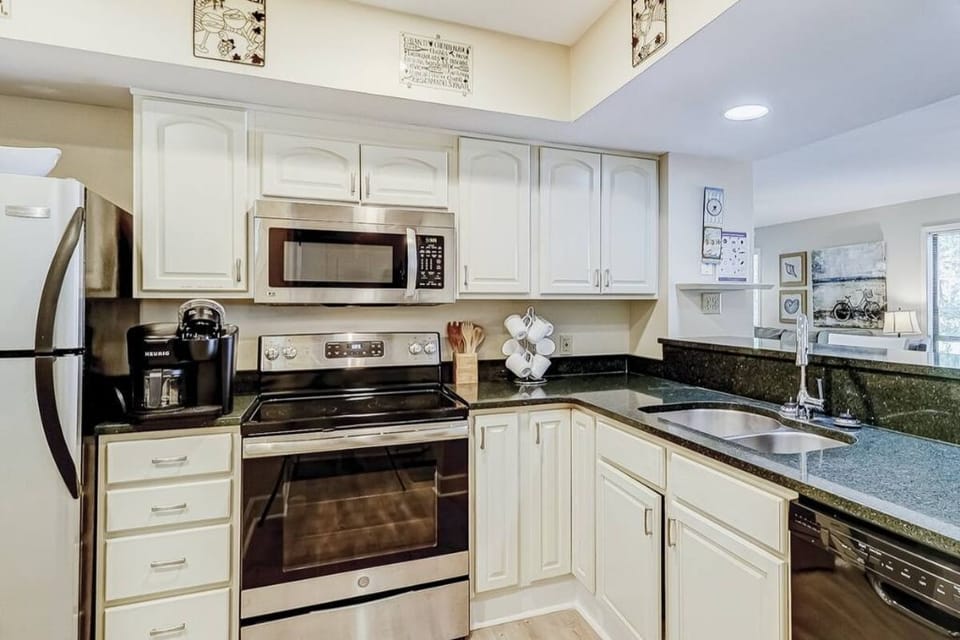 Stainless steel appliances.  Olivine quartz stone countertop.  