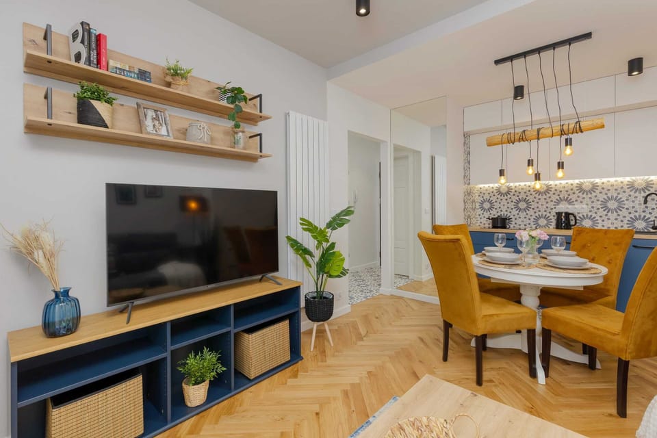 A close-up of a dining area with a wooden table, stylish plates, and decorative plants.
