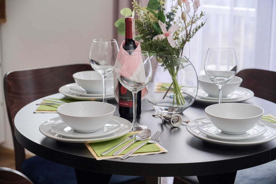 A dining table set with elegant plates, glasses, and fresh flowers, perfect for a special occasion.

