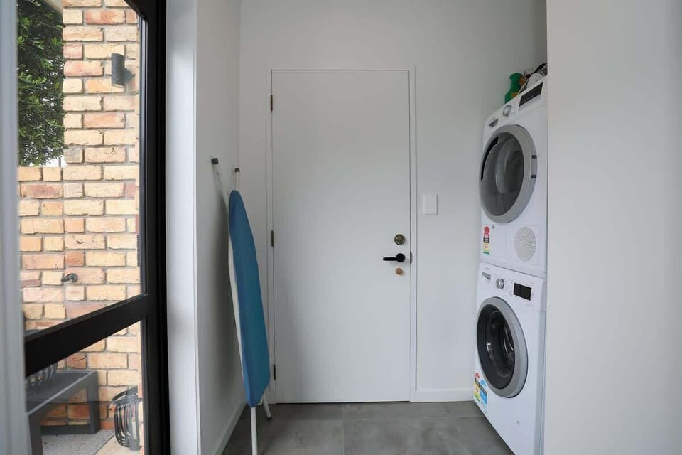 The laundry has a washer and dryer plus an iron and board.
