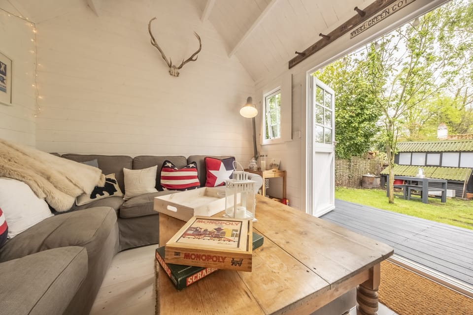 Well Green Cottage, Wenhaston: Summerhouse with a wood burning stove and large sofa