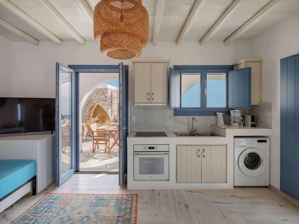 Fully equipped kitchenette with washing machine and cozy seating area.