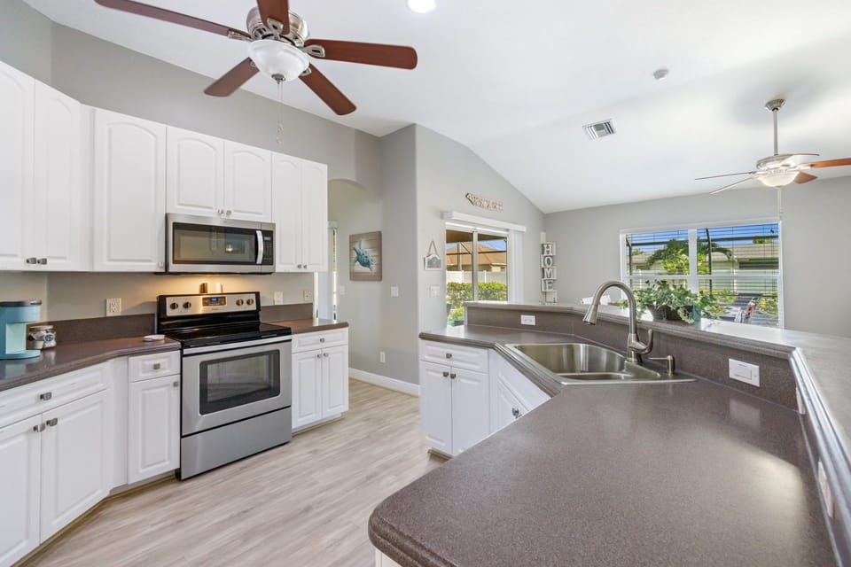 Bright open kitchen with bar seating and seamless flow to dining and patio.