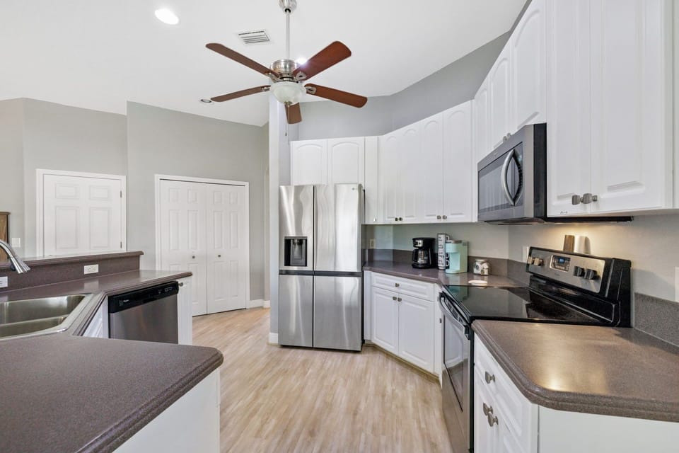 Bright open kitchen with bar seating and seamless flow to dining and patio.