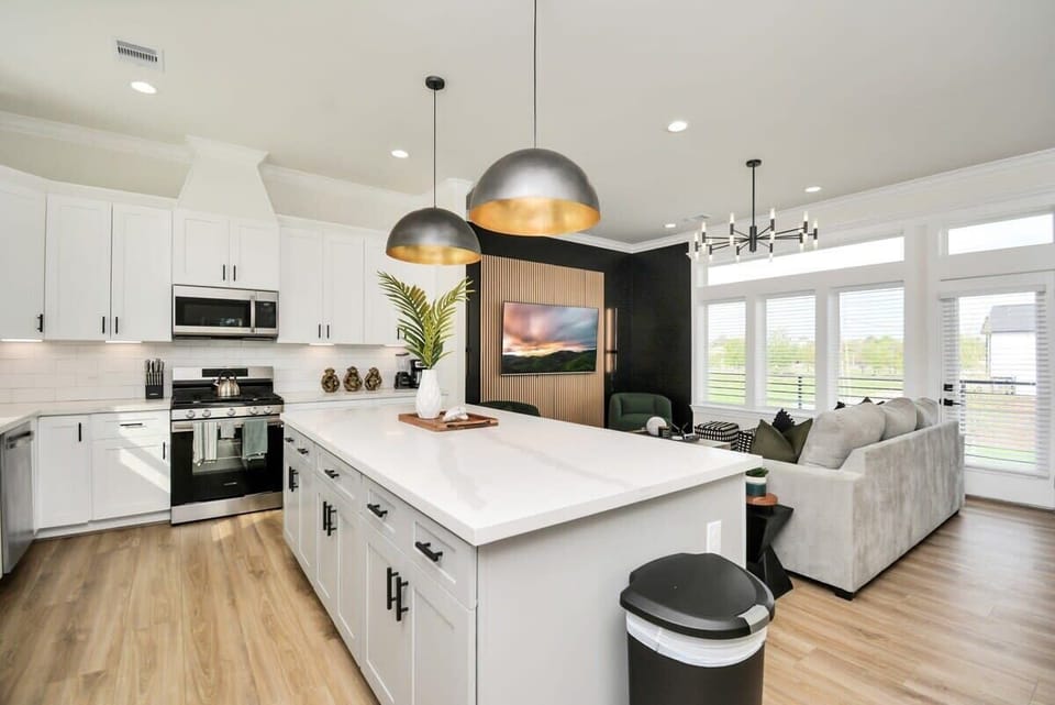 FULLY STOCKED Large Kitchen and Island. Accented with large gold pendant lights. Perfect for entertaining and hosting larger groups. 