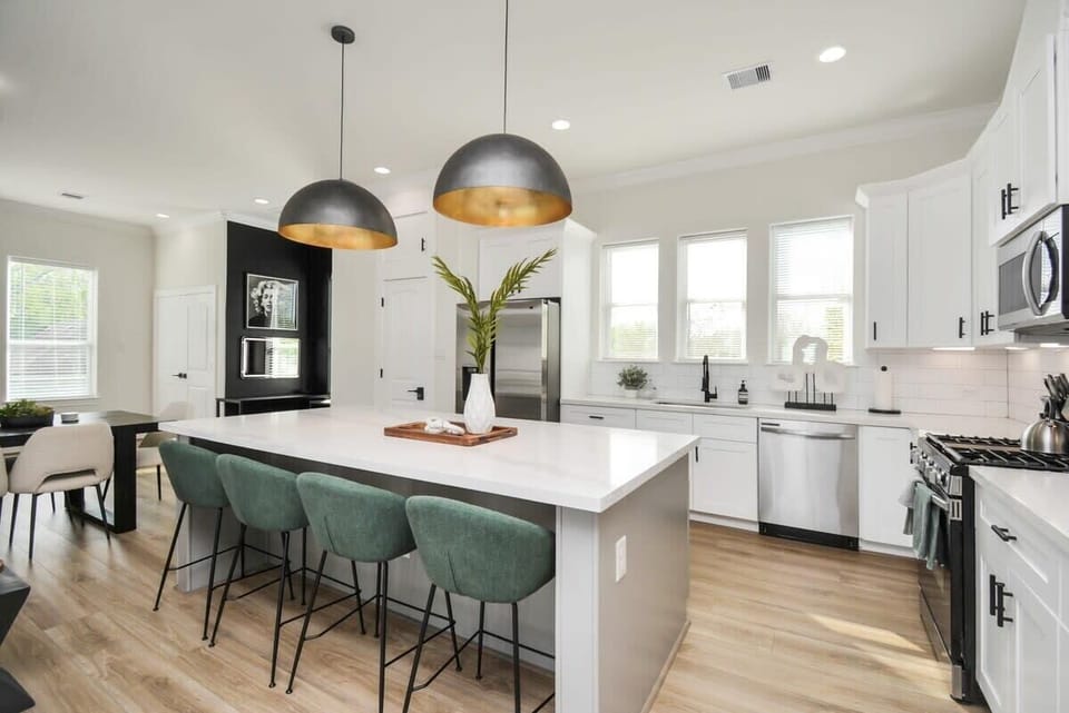 FULLY STOCKED Large Kitchen and Island. Accented with large gold pendant lights. Perfect for entertaining and hosting larger groups. 