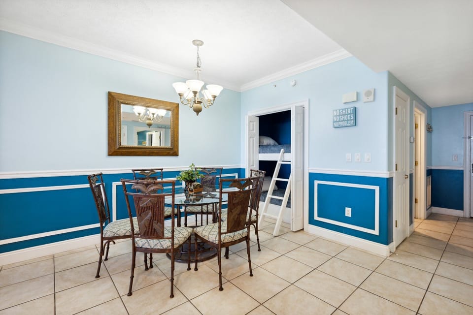 Dining area w/ seating for shared meals, framed by cheerful blue accents & natural light