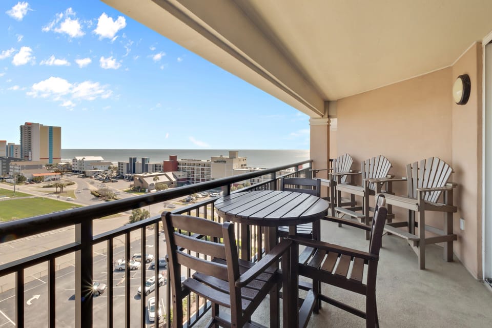 Your private balcony features comfortable seating and sweeping city views, perfect for morning coffee or sunset relaxation.