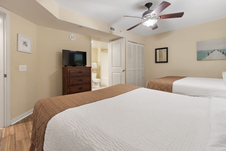 Relax in your comfortable twin bedroom with ceiling fan, TV entertainment, and private bathroom access for restful nights.