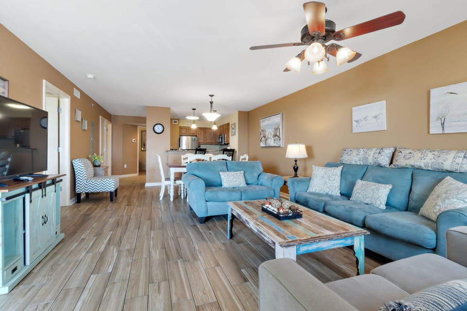 Relax in your spacious open-concept retreat, where coastal blue accents and warm wood floors create the perfect atmosphere for unwinding after beach adventures.