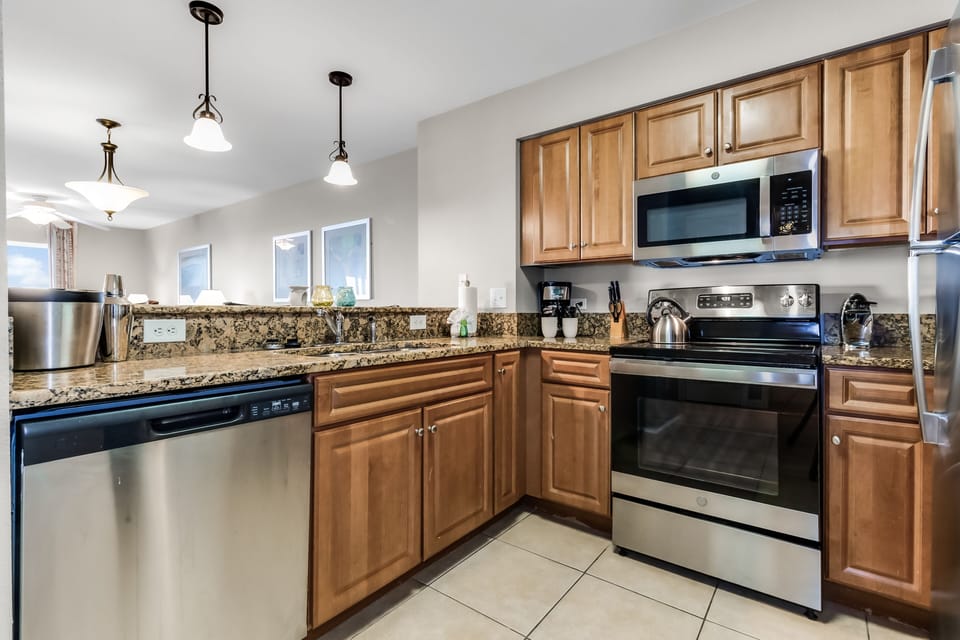 Your fully equipped kitchen features granite countertops, stainless steel appliances, and warm wood cabinets—perfect for preparing meals during your stay.