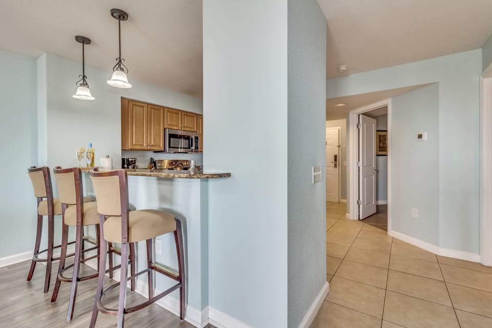 Your open kitchen features a breakfast bar where you can enjoy morning coffee while pendant lights create perfect ambiance for cooking.