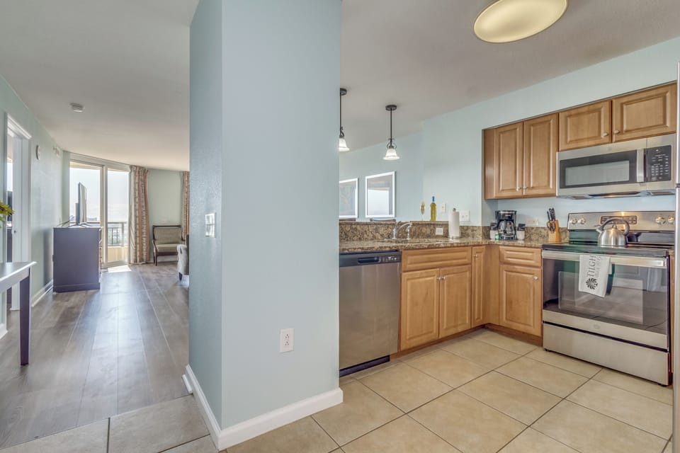 Your fully-equipped kitchen features granite countertops, stainless steel appliances, and flows seamlessly into the bright living space with city views.