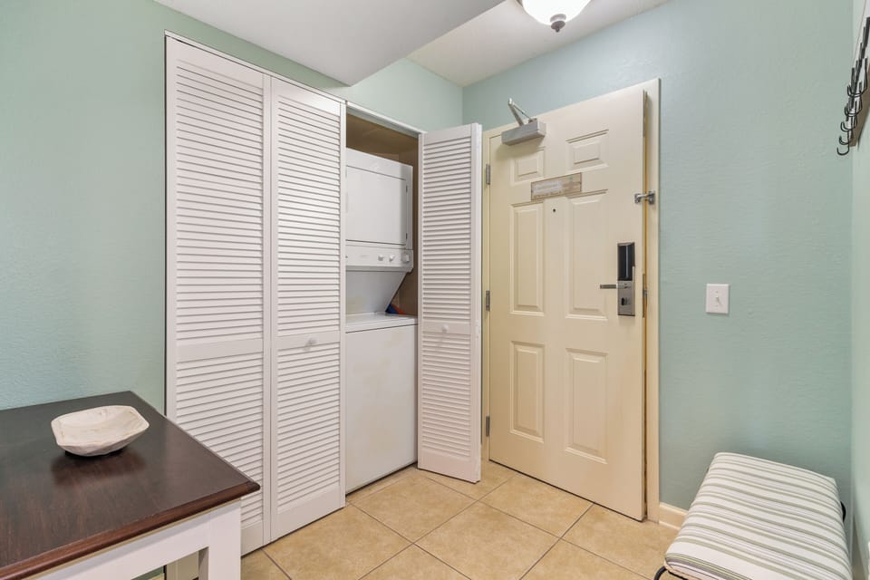 Your private laundry space keeps you organized with stacked washer-dryer and ample storage behind elegant louvered doors.