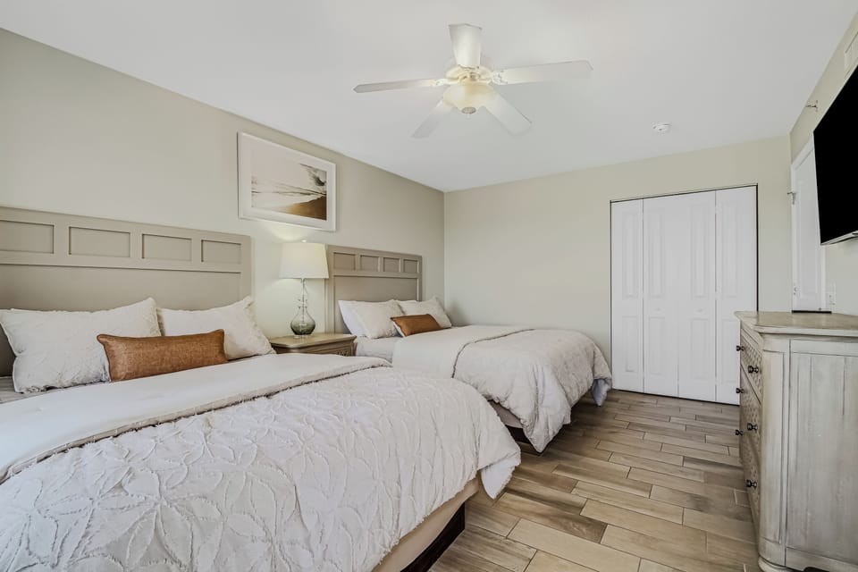 Your comfortable bedroom features two plush beds with crisp linens, ample storage, and a ceiling fan for peaceful nights.
