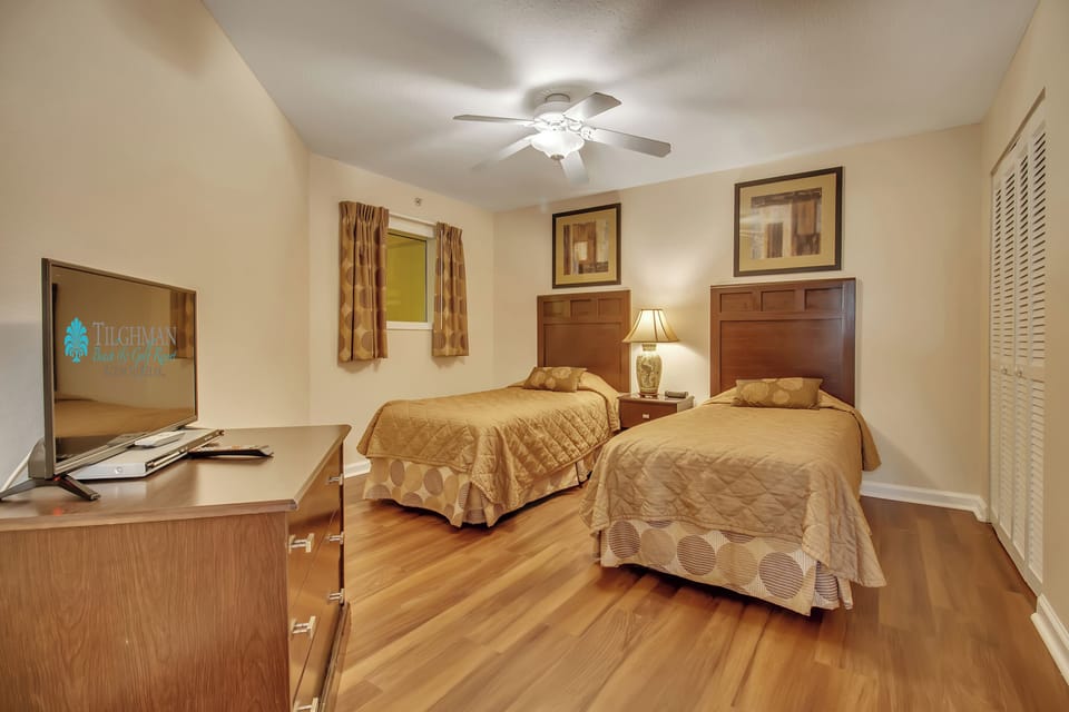Rest peacefully in your twin bedroom with comfortable beds, warm wood furnishings, and a ceiling fan for perfect temperature control.