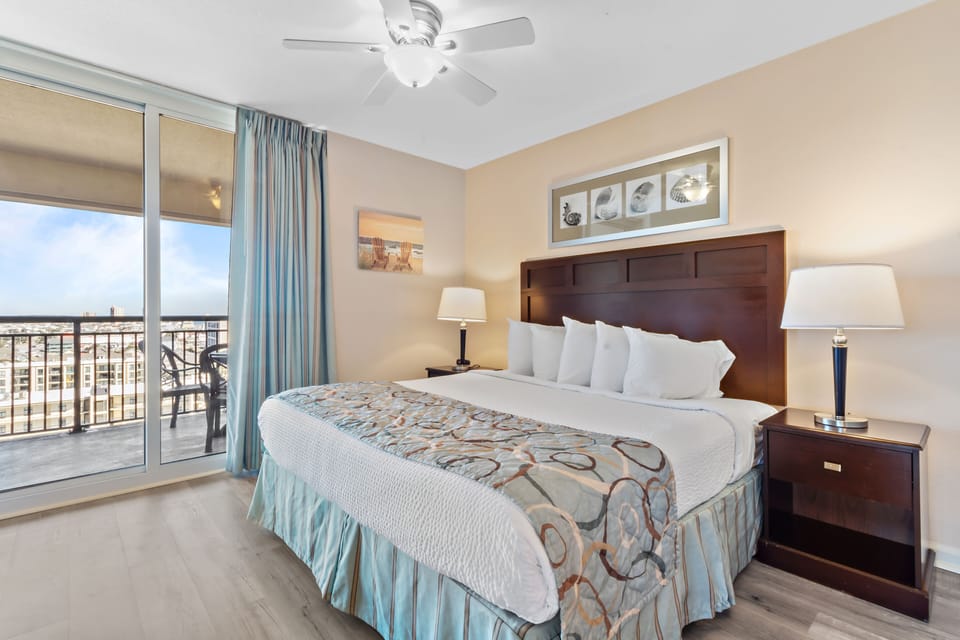 Unwind in your peaceful bedroom with city views from your private balcony, crisp linens, and gentle ceiling fan breeze.