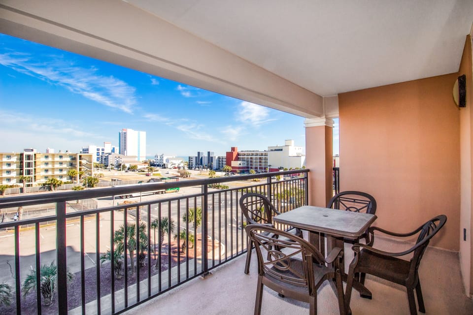 Enjoy your morning coffee on this spacious balcony with sweeping city views and comfortable outdoor dining for four.