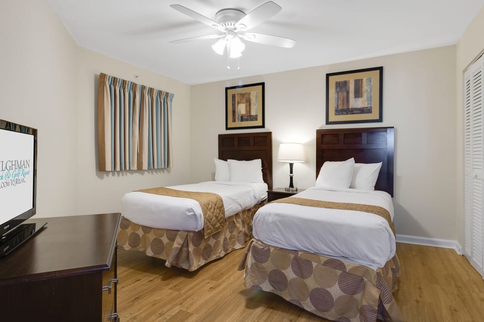Rest comfortably in your twin bedroom featuring crisp linens, warm wood accents, and ceiling fan for perfect temperature control.