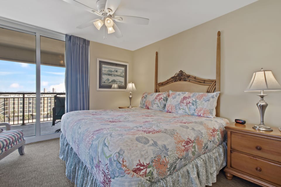 Wake up to stunning city views from your comfortable four-poster bed, where coastal-themed linens and gentle ceiling fan breezes create the perfect retreat.