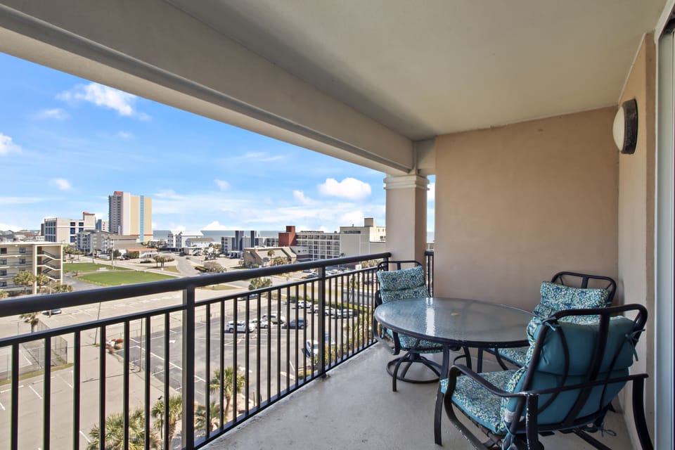 Step onto your private balcony and savor morning coffee while taking in sweeping city views from your comfortable outdoor dining space.