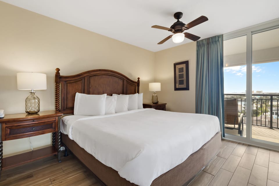 Unwind in your coastal bedroom featuring crisp white linens, tropical décor, and your own private balcony with stunning views.