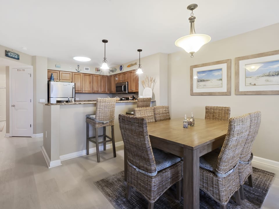 Gather around your stylish dining table for family meals, with coastal artwork creating a peaceful atmosphere in your open-concept space.