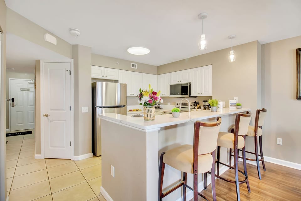 Your spacious kitchen welcomes you with gleaming counters, modern appliances, and a breakfast bar perfect for morning coffee.