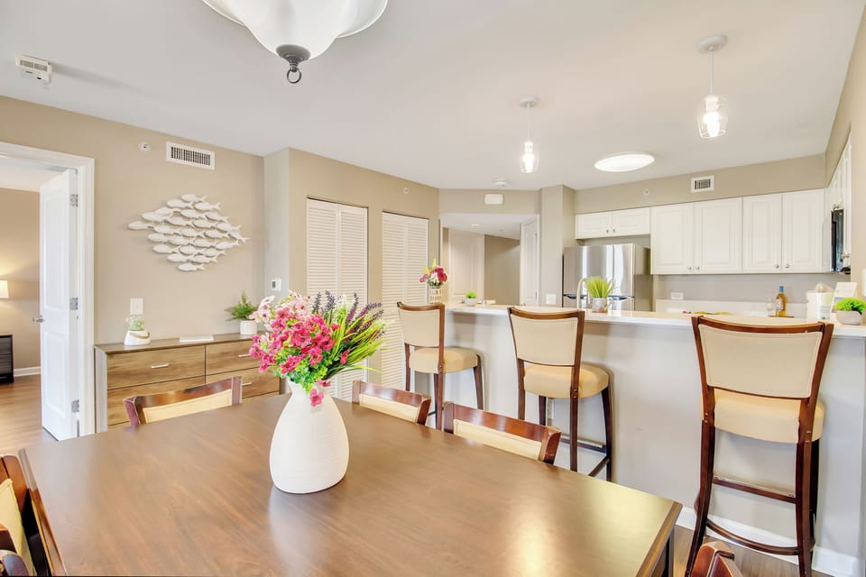 Your modern open-plan kitchen and dining space features fresh flowers and stylish seating for memorable meals together.