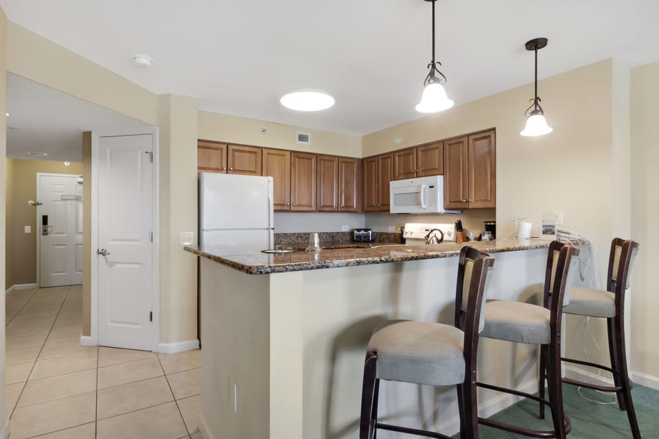 Your fully equipped kitchen awaits with granite counters, breakfast bar seating, and modern appliances for memorable home-cooked meals together.