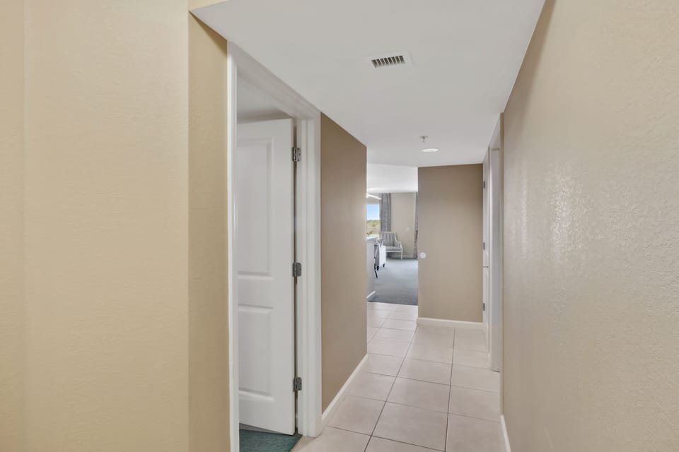 A welcoming hallway leads you to your retreat, with clean tile floors and warm neutral tones creating a peaceful pathway to relaxation.