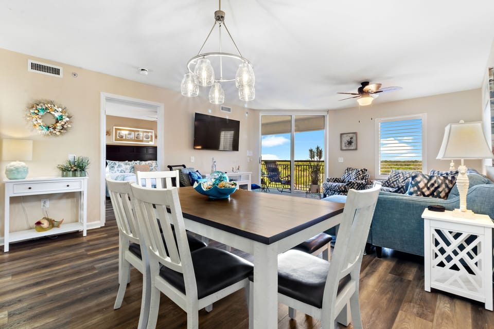 Gather around your elegant dining table while enjoying sweeping views through floor-to-ceiling windows, creating the perfect backdrop for memorable meals together.